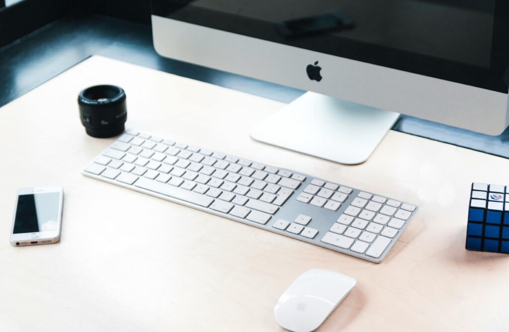 Stylish office desk setup featuring a computer, smartphone, keyboard, and accessories for tech enthusiasts.