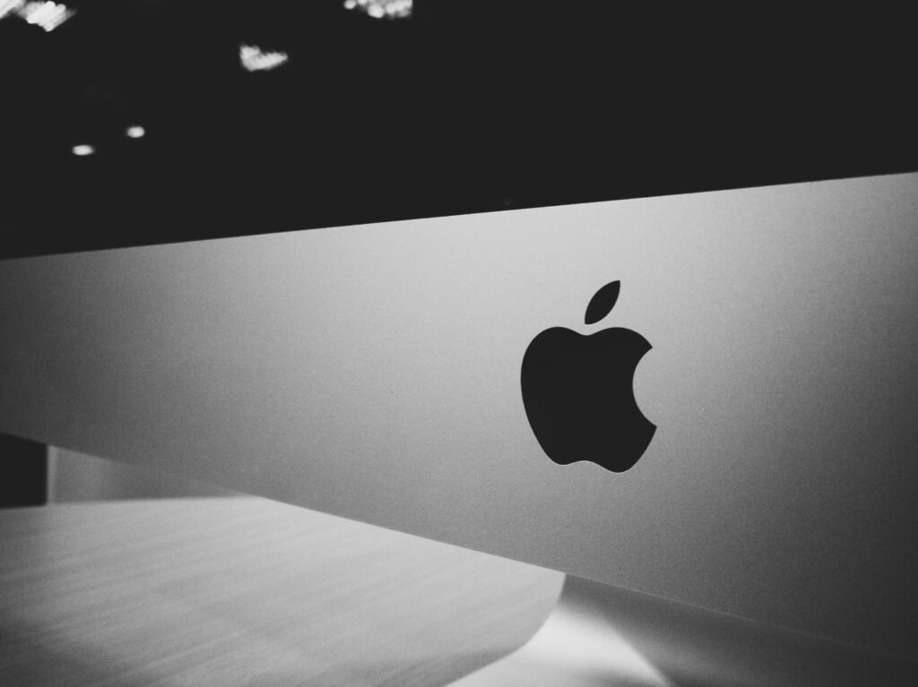 Close-up of a black and white Apple logo on a desktop screen with a modern minimalist design.